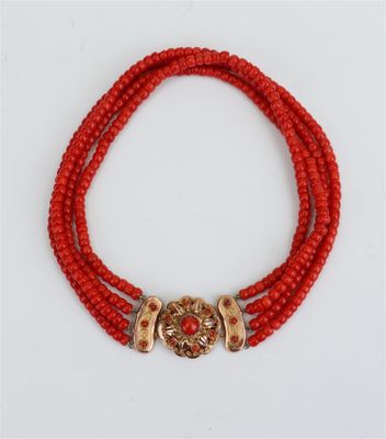 un collier de perles rouges, composé de perles dorées et rouges