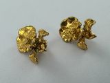 two pairs of gold earrings on a white surface