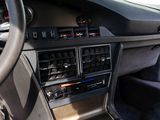 a car dashboard with various electronic controls and a steering wheel