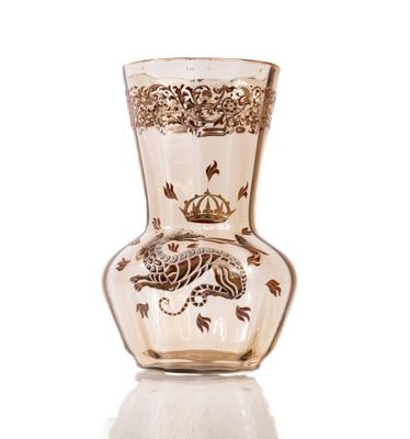 a glass vase with a dragon on it on a white surface