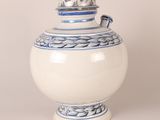 a blue and white vase with a lid sitting on a table