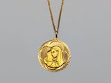 a gold necklace with a picture of a woman on it