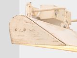 underside view of a wooden model of a boat on a white surface