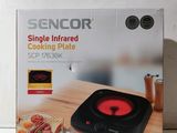 boîte contenant une plaque de cuisson infrarouge posée sur une table en bois