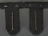 two pieces of black cloth with gold thread and a pair of scissors