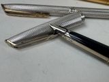 a pen that is laying on a table next to a ruler