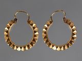a pair of gold hoop earrings with a circular design