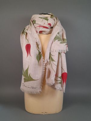 beige scarf with red radishes and leaves on it on a mannequin head