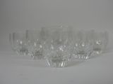 six wine glasses lined up on a white surface