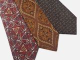 trois cravates de couleurs différentes, ornées de motifs sur fond blanc