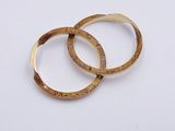 two gold rings on a white surface with a white background