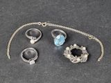 trois bagues et un collier posés sur une table, avec une chaîne
