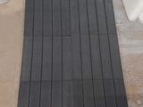 a black mat sitting on the floor next to a toilet