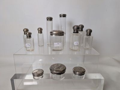 a display of glass jars with silver lids on a clear shelf