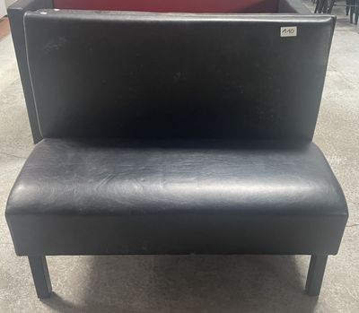 un banc noir posé au milieu d'une pièce