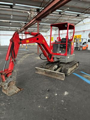 une pelleteuse rouge garée dans un grand entrepôt