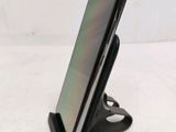 a close up of a cell phone on a stand on a white surface