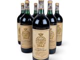four bottles of wine are lined up on a white surface