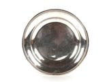 une assiette ancienne en argent, ornée d'un motif circulaire sur fond blanc