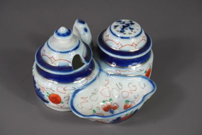 une petite théière bleue et blanche avec un couvercle, posée sur une table