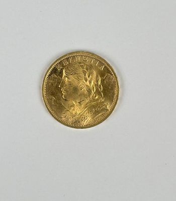 gros plan d'une pièce d'or sur une surface blanche