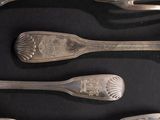 five spoons and a fork on a black surface