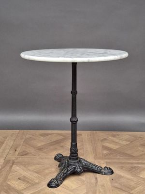 a white marble top table on a wooden floor