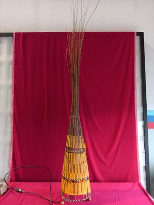 a vase that has a bunch of sticks in it on a table