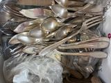une boîte remplie de cuillères en argent, avec des cuillères à l'intérieur