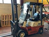 un chariot élévateur dans un entrepôt rempli de palettes et de cartons