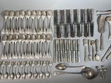 a lot of silver spoons and spoon knives on the table