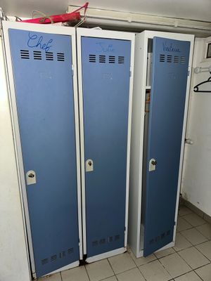 three blue lockers in a room with a tiled floor