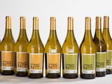 six bouteilles de vin blanc sont alignées