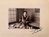 black and white photograph of a woman sitting on the floor reading a book