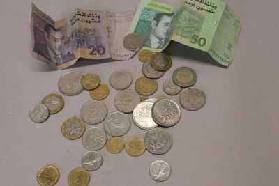 une pile d'argent posée sur une table à côté d'une pile de pièces de monnaie