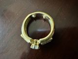 une photo d'une bague en or posée sur une table, sertie d'un diamant