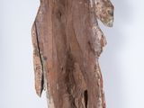 an image of a wooden statue of a man holding a cross