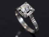 a close up of a diamond ring on a black surface