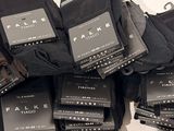 many pairs of black socks stacked on top of each other