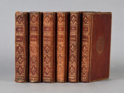 four old books sitting on top of each other on a table