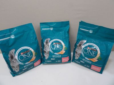 trois sacs de nourriture pour chat posés sur une table