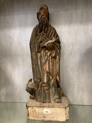 statue en bois représentant un homme barbu tenant un chien dans ses bras