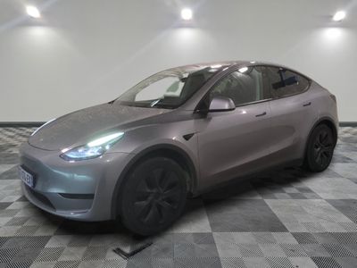 Le SUV Tesla argenté est garé sur un sol à damier.