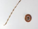 a gold chain with a button on it next to a button