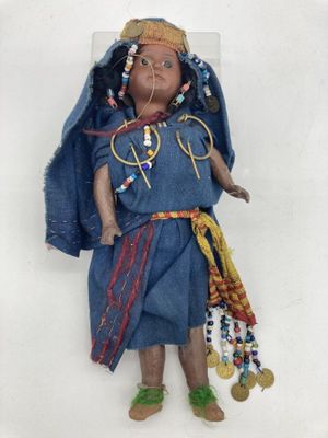 a doll that is wearing a blue dress and a hat