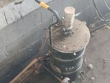 a black bucket with a yellow handle sitting next to a wall