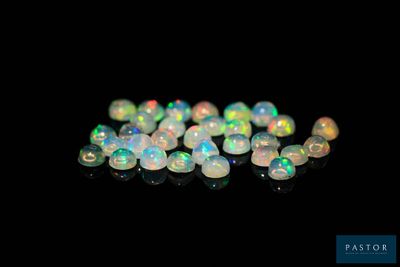 a close up of a bunch of white oplite beads on a black surface