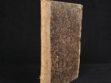 an old book sitting on top of a black surface