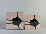 two boxes with a pair of black glasses on them on a white surface