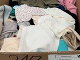 a cardboard box full of clothes that is on display